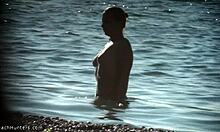 Μεγάλο στήθος μωρό με φυσικό σώμα περπατά σε παραλία γυμνιστών