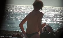 Nudista loira tira a roupa na praia