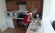Czerwona blondynka wstaje i robi naczynia, patrząc gorąco