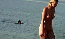 Wanita berpayudara besar berambut pirang menikmati aktivitas seksual di pantai nudis